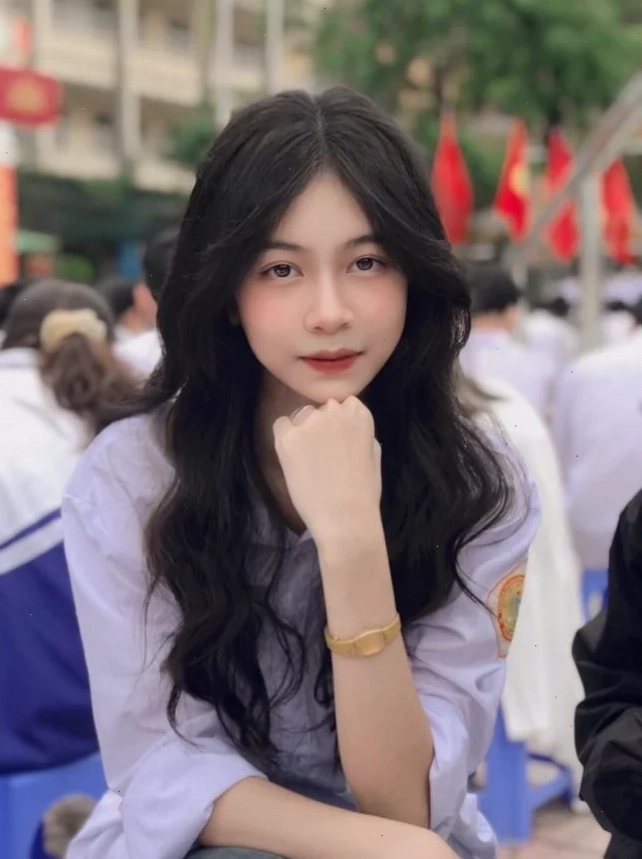 Ảnh gái 2k5 tóc đen chụp cận mặt giữa nền lá vàng rực rỡ