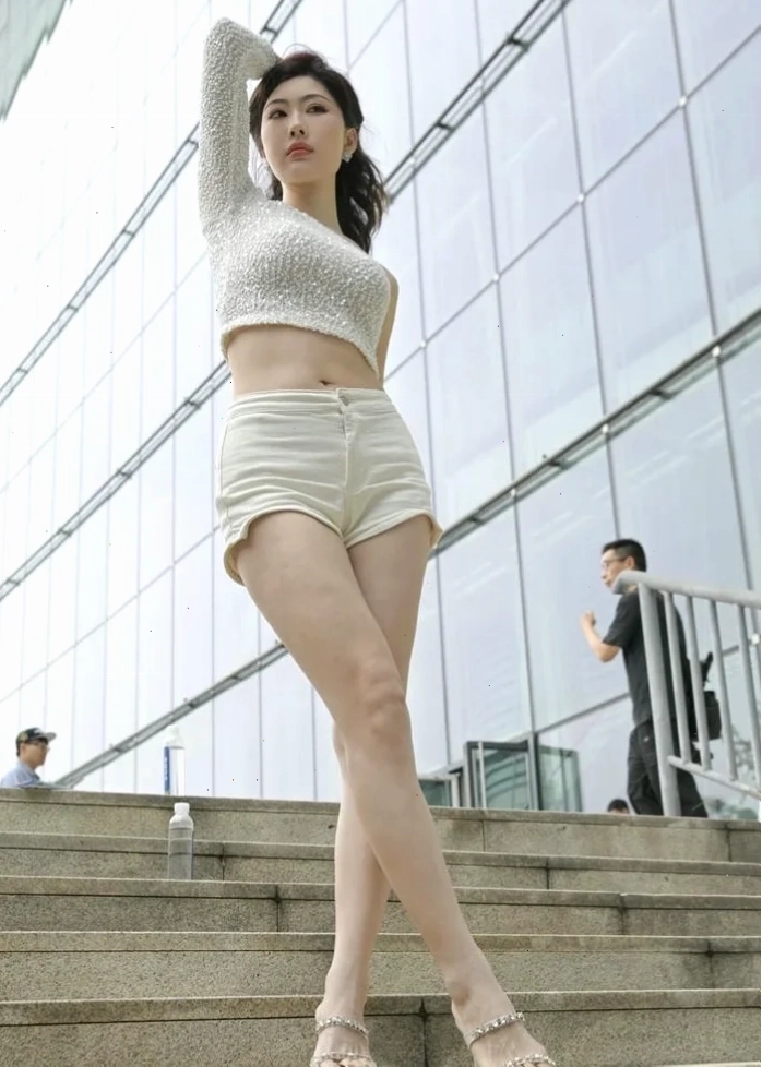 ảnh gái mặc quần short bên tường đá