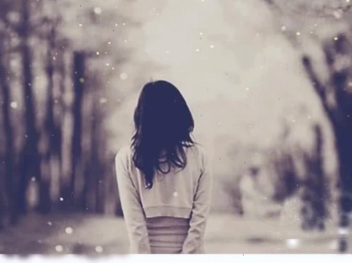 Cô gái đứng trên đồi cỏ nhìn về phía xa với phía sau lưng cô gái