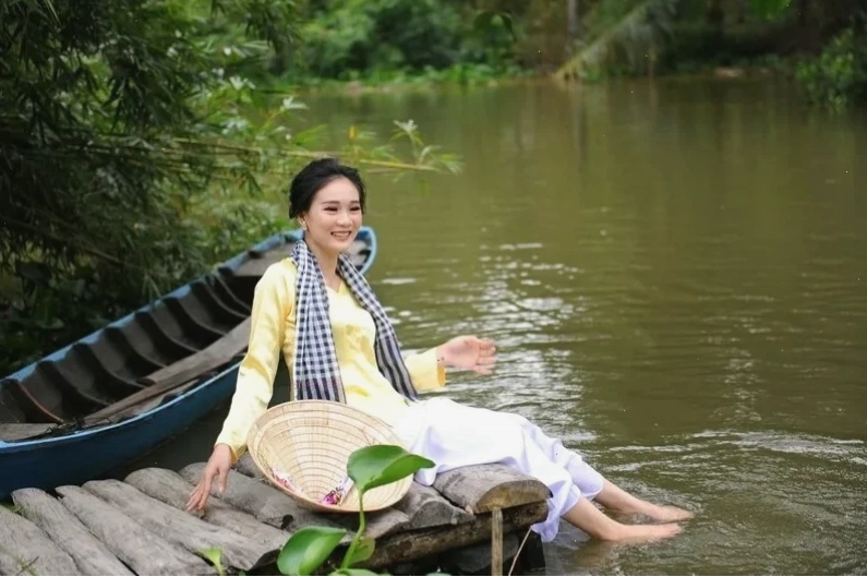 cô gái mặc áo bà ba ngồi