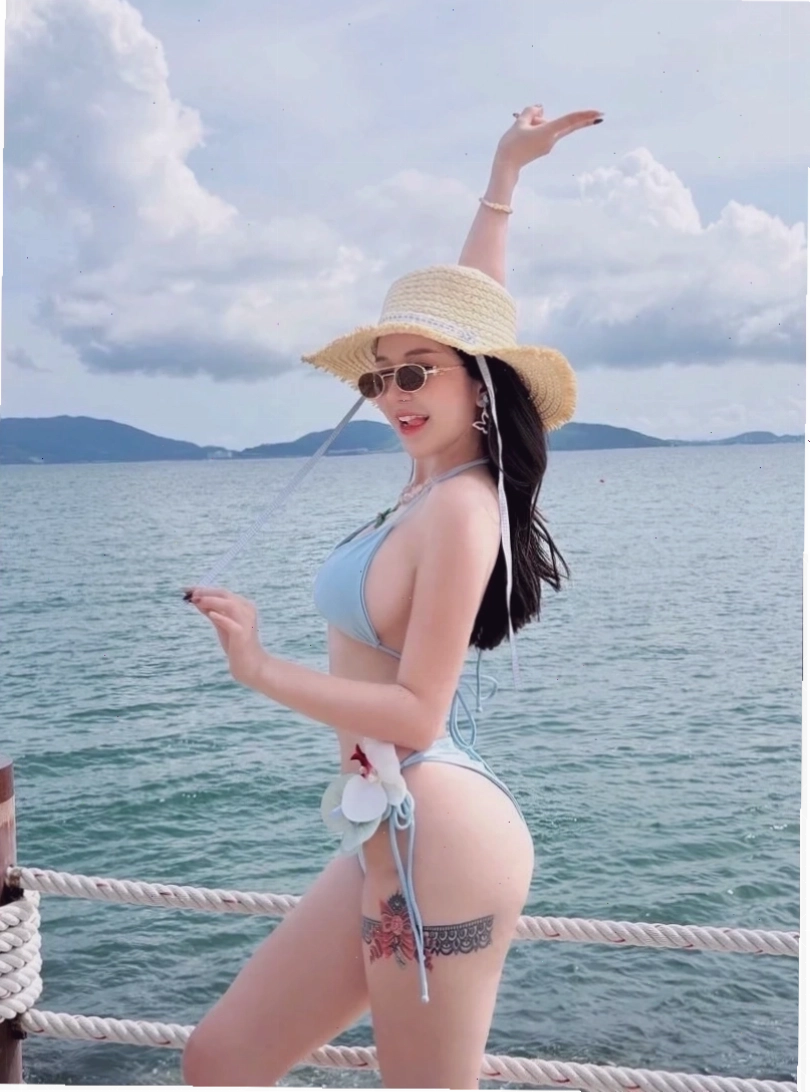 gái xinh mặc bikini đi biển che mặt ngồi trên ghế
