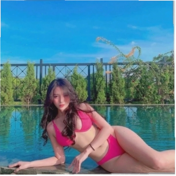 Gái xinh mặc bikini hồng nằm trên cát
