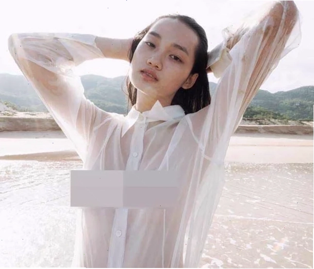 Một cô gái mặc áo sơ mi trắng ướt tại bãi biển