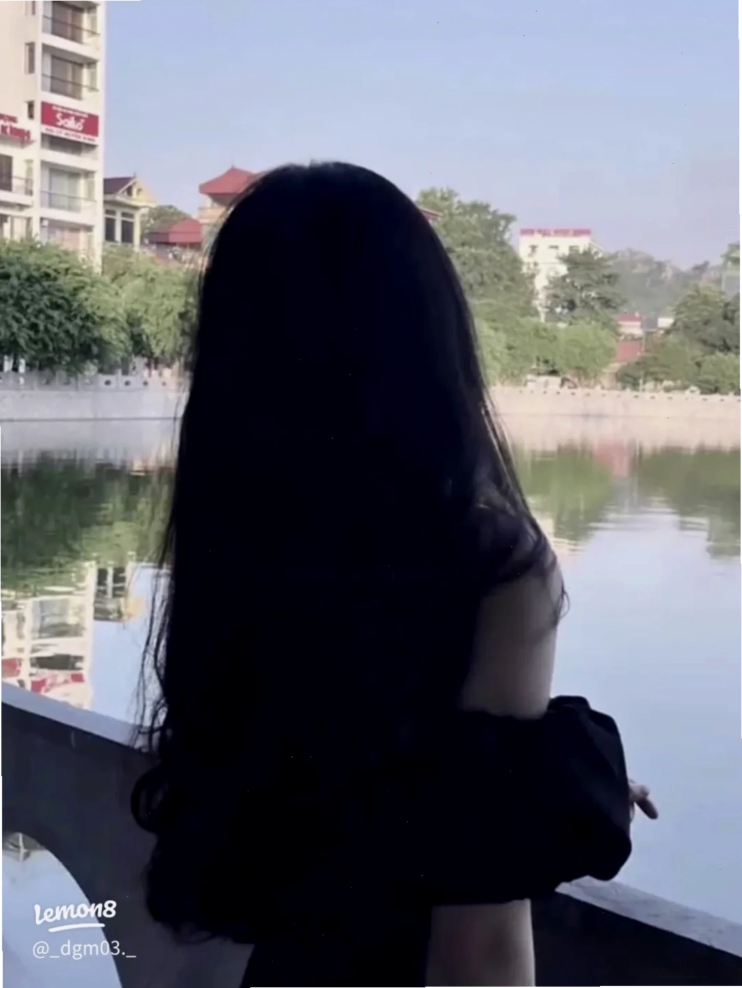 Phía sau lưng cô gái đứng giữa cánh đồng