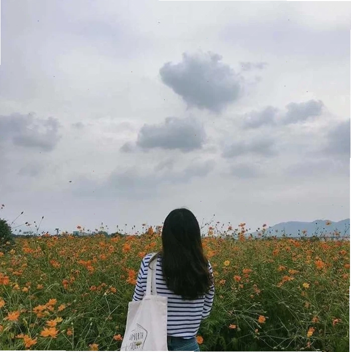 Phía sau lưng cô gái đứng trong ánh đèn màu